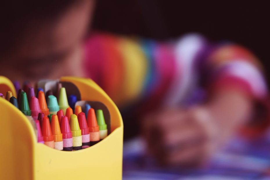 child coloring with crayons